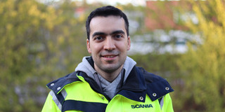 Ein Portraitbild des Absolventen Sina Sharif Mansouri in gelber Warnjacke