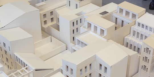 Modell einer Stadt, das aus weißen Hochhäusern mit unterschiedlicher Stockwerkzahl gebaut ist.